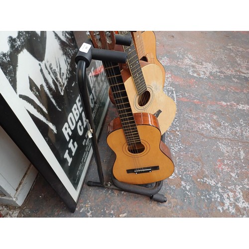 671 - Three acoustic guitars with folding five capacity stand, one Kapok child's, one Powerplay steel stru... 