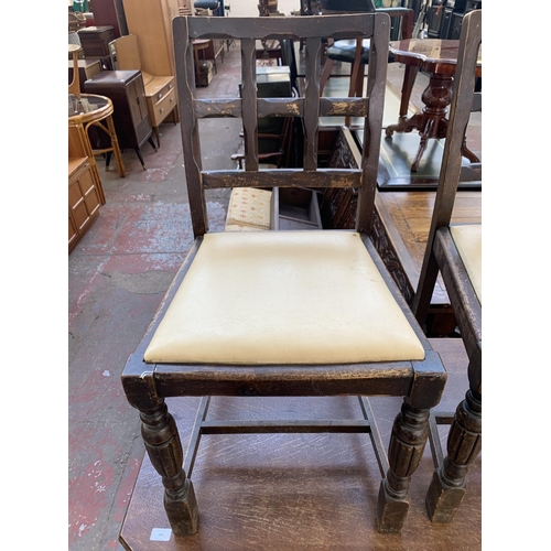 78 - An Art Deco carved oak octagonal drop leaf dining table and two chairs - approx. 74cm high x 106cm w... 