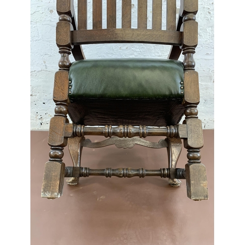 14 - An early 20th century carved oak and green leatherette upholstered carver chair - approx. 120cm high... 