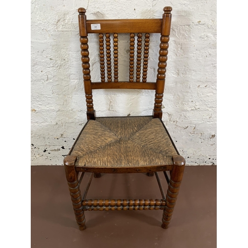 162 - A 19th century oak bobbin turned occasional chair with rush seat - approx. 94cm high x 46cm wide x 3... 