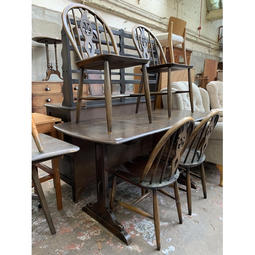 60 - An Ercol Old Colonial dark elm and beech dining table and four Fleur De Lys dining chairs