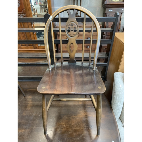 60 - An Ercol Old Colonial dark elm and beech dining table and four Fleur De Lys dining chairs