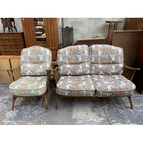 67 - An Ercol beech wheelback two piece lounge suite comprising two seater sofa and armchair