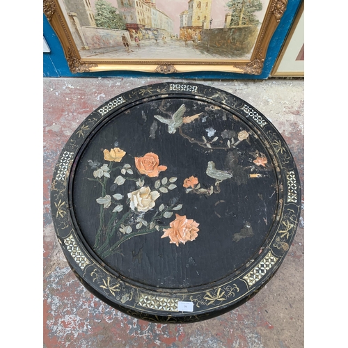 79 - An Oriental black lacquered and mother of pearl inlaid circular coffee table with bird and foliate r... 