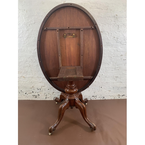 93 - A Victorian mahogany oval tilt top breakfast table on quatrefoil base - approx. 145cm high when tilt... 