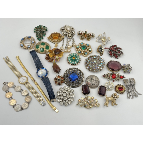 2233 - A collection of costume jewellery to include brooches, coin bracelet etc.