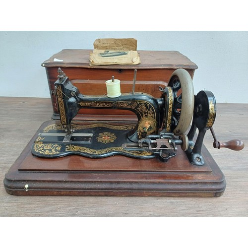 858 - A cased late 19th century Bradbury & Company Limited hand-crank fiddle-base sewing machine with inst... 