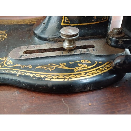 858 - A cased late 19th century Bradbury & Company Limited hand-crank fiddle-base sewing machine with inst... 