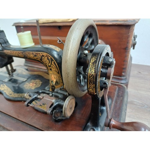 858 - A cased late 19th century Bradbury & Company Limited hand-crank fiddle-base sewing machine with inst... 