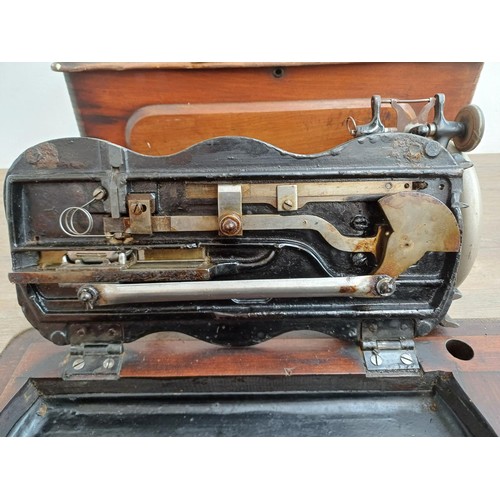 858 - A cased late 19th century Bradbury & Company Limited hand-crank fiddle-base sewing machine with inst... 