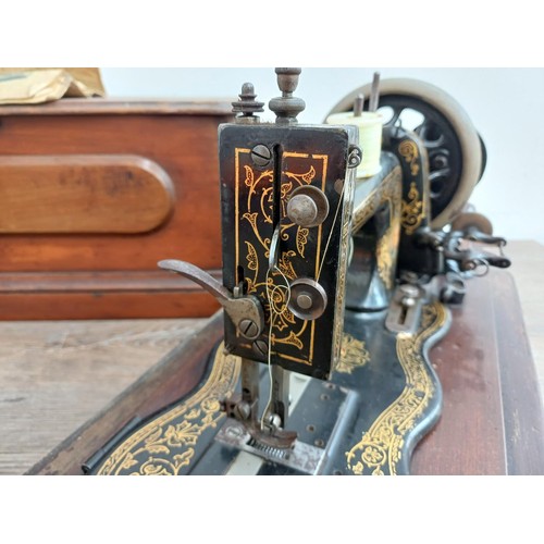 858 - A cased late 19th century Bradbury & Company Limited hand-crank fiddle-base sewing machine with inst... 