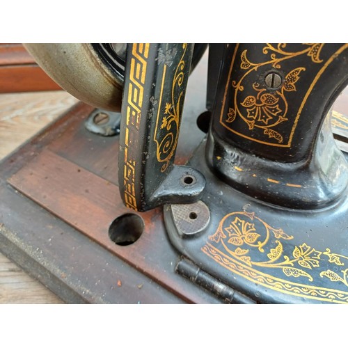 858 - A cased late 19th century Bradbury & Company Limited hand-crank fiddle-base sewing machine with inst... 