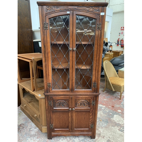 175 - An Old Charm carved oak free standing corner cabinet - approx. 167cm high