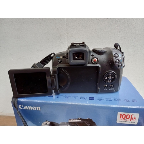 665 - A boxed Canon PowerShot SX10 IS 10mp digital camera with cable, software discs and instruction manua... 