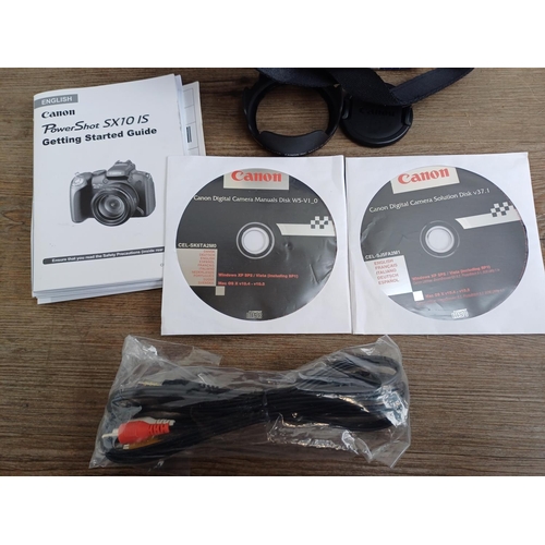 665 - A boxed Canon PowerShot SX10 IS 10mp digital camera with cable, software discs and instruction manua... 