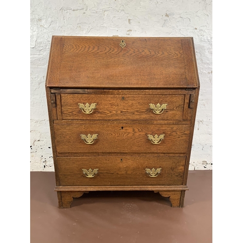 211 - A Georgian oak bureau on bracket supports - approx. 98cm high x 76cm wide x 39cm deep