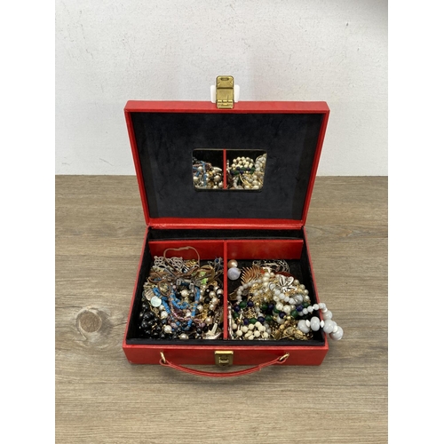 513 - A red faux leather jewellery box containing a collection of assorted costume jewellery to include 19... 