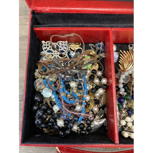 513 - A red faux leather jewellery box containing a collection of assorted costume jewellery to include 19... 