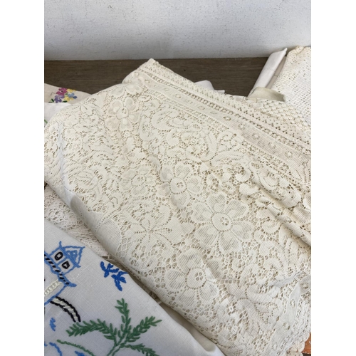 518 - A collection of vintage linen to include embroidered tablecloth, lace tablecloth etc.