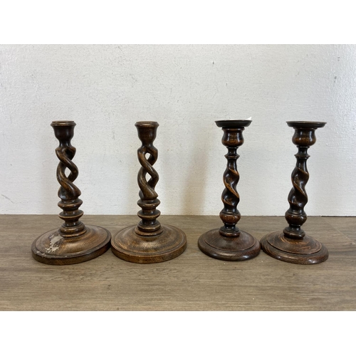 543 - Seven pieces of treenware, four barley twist candlesticks, a pair of oriental water buffalo figurine... 