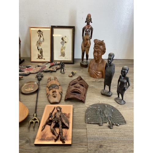 572 - A collection of African figurines and wall plaques to include carved teak wall mask, butterfly wing ... 