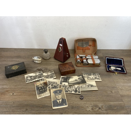 573 - A collection of items to include West German Wittner metronome, black and white photographs, leather... 