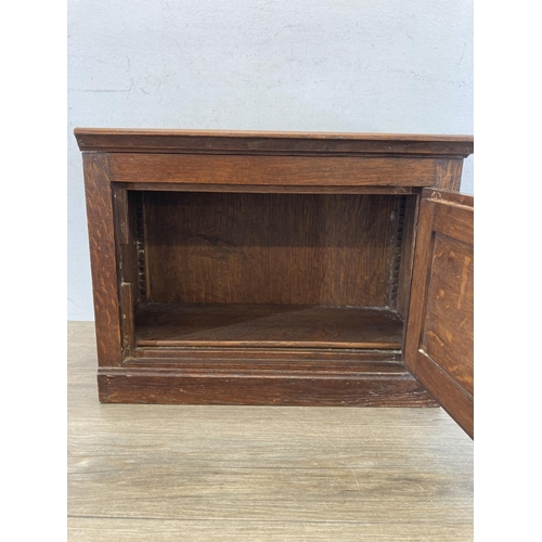 579 - An early 20th century oak single door cabinet - approx. 30cm high x 39.5cm wide x 20cm deep