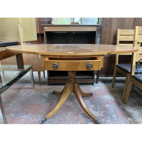 137 - A Regency style yew wood oval drop leaf pedestal breakfast table - approx. 78cm high x 94cm wide x 1... 