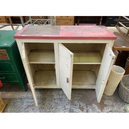 149 - A 1950s red laminate and white painted three door kitchen cabinet - approx. 92cm high x 109cm wide x... 