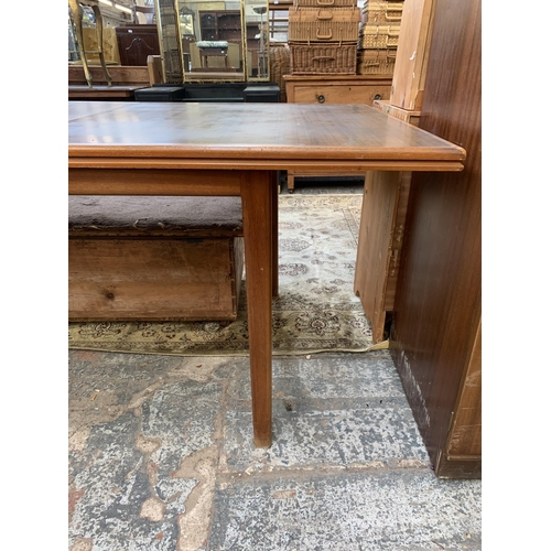 151 - A mid 20th century A.H. McIntosh & Co Ltd teak and walnut extending dining table - approx. 76cm high... 