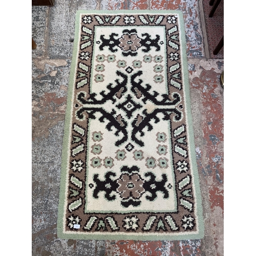 152 - A mid 20th century machine woven woollen rug - approx. 178cm x 92cm wide