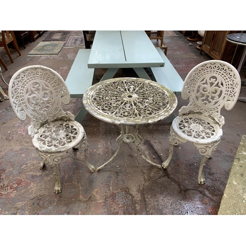 160 - A Victorian style white painted cast metal three piece patio set comprising circular table and two c... 