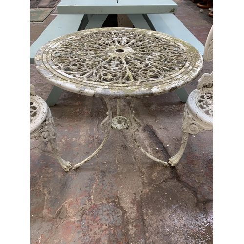 160 - A Victorian style white painted cast metal three piece patio set comprising circular table and two c... 