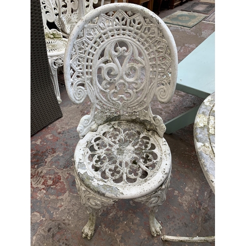 160 - A Victorian style white painted cast metal three piece patio set comprising circular table and two c... 