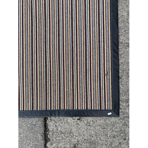 163 - A modern black leatherette and striped rug - approx. 225cm x 160cm