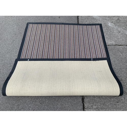 163 - A modern black leatherette and striped rug - approx. 225cm x 160cm