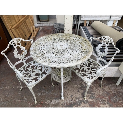 169 - A Victorian style white painted cast metal three piece patio set comprising circular table and two c... 