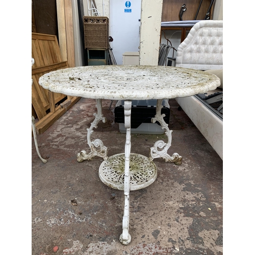 169 - A Victorian style white painted cast metal three piece patio set comprising circular table and two c... 