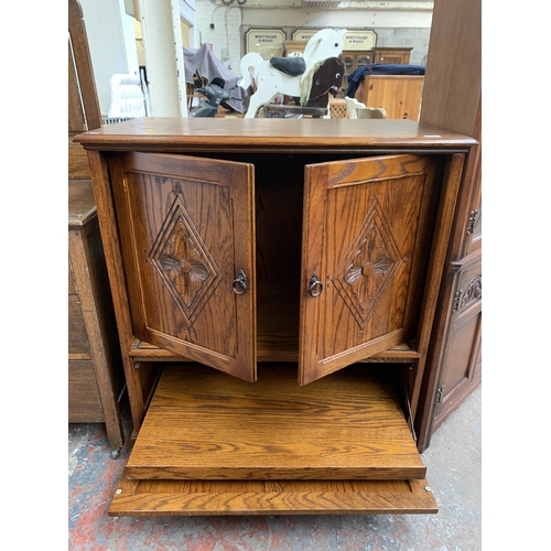 177 - A carved oak TV cabinet - approx. 104cm high x 94cm wide x 53cm deep