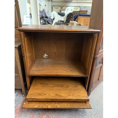 177 - A carved oak TV cabinet - approx. 104cm high x 94cm wide x 53cm deep