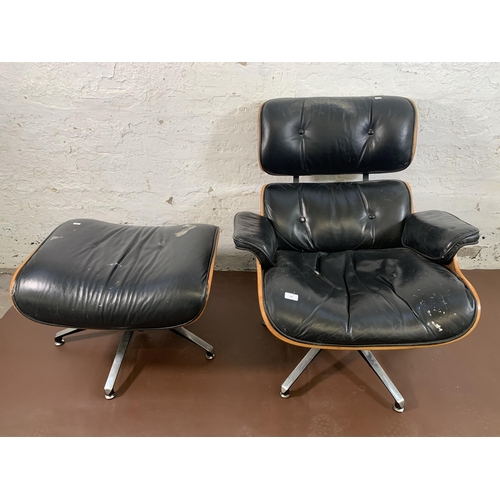 189 - A Charles & Ray Eames style black vinyl and simulated rosewood revolving lounge chair and ottoman