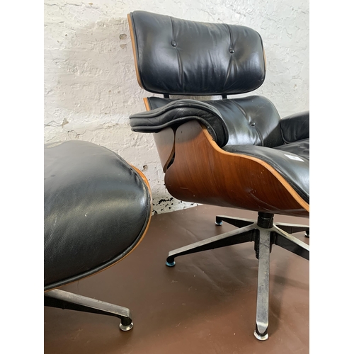 189 - A Charles & Ray Eames style black vinyl and simulated rosewood revolving lounge chair and ottoman