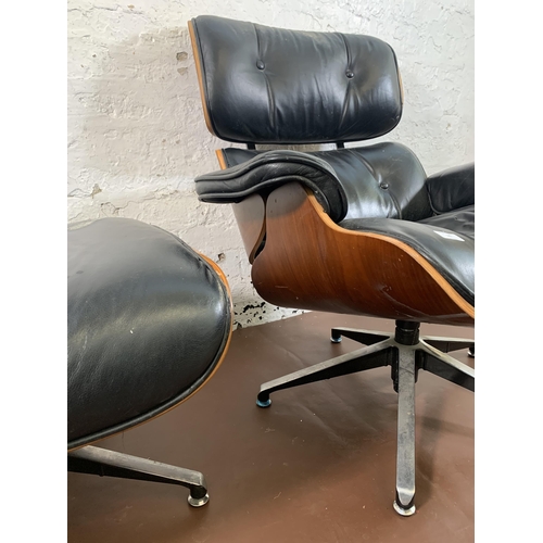 189 - A Charles & Ray Eames style black vinyl and simulated rosewood revolving lounge chair and ottoman