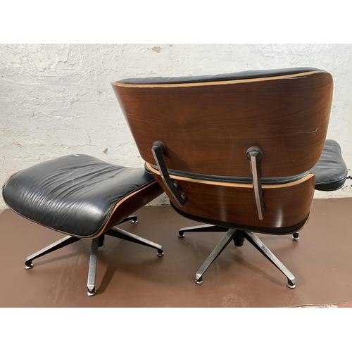 189 - A Charles & Ray Eames style black vinyl and simulated rosewood revolving lounge chair and ottoman