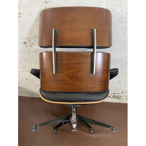 189 - A Charles & Ray Eames style black vinyl and simulated rosewood revolving lounge chair and ottoman