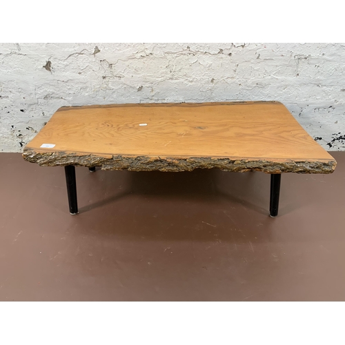 205 - A mid 20th century elm tree slice coffee table on ebonised supports - approx. 30cm high x 48cm wide ... 