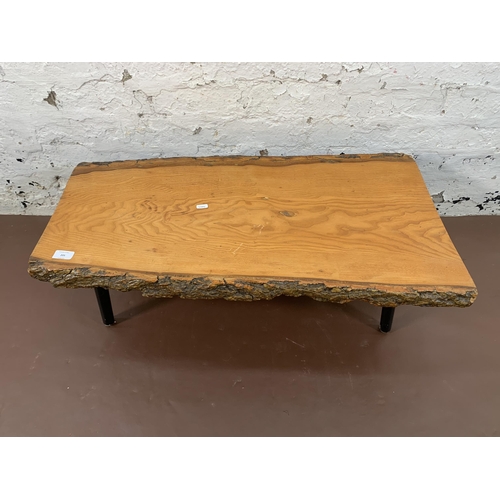 205 - A mid 20th century elm tree slice coffee table on ebonised supports - approx. 30cm high x 48cm wide ... 