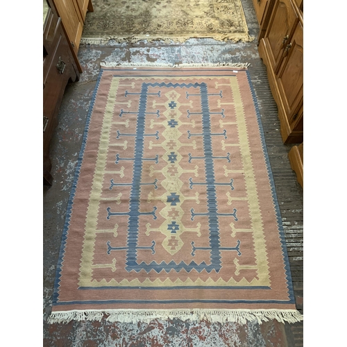 222 - A mid 20th century pink and blue geometric pattern rug - approx. 190cm x 128cm