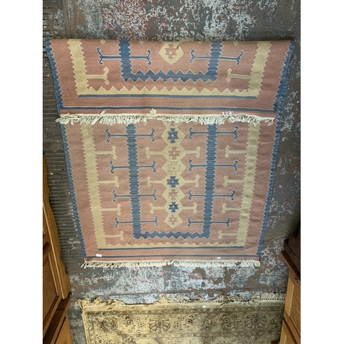 222 - A mid 20th century pink and blue geometric pattern rug - approx. 190cm x 128cm