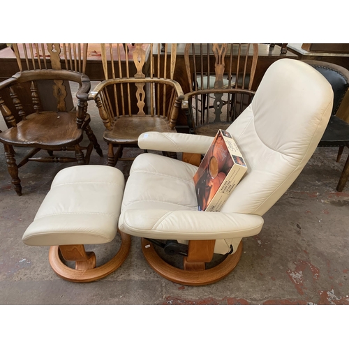 223 - An Ekornes Stressless cream leather and bentwood swivel reclining armchair and footstool with boxed ... 